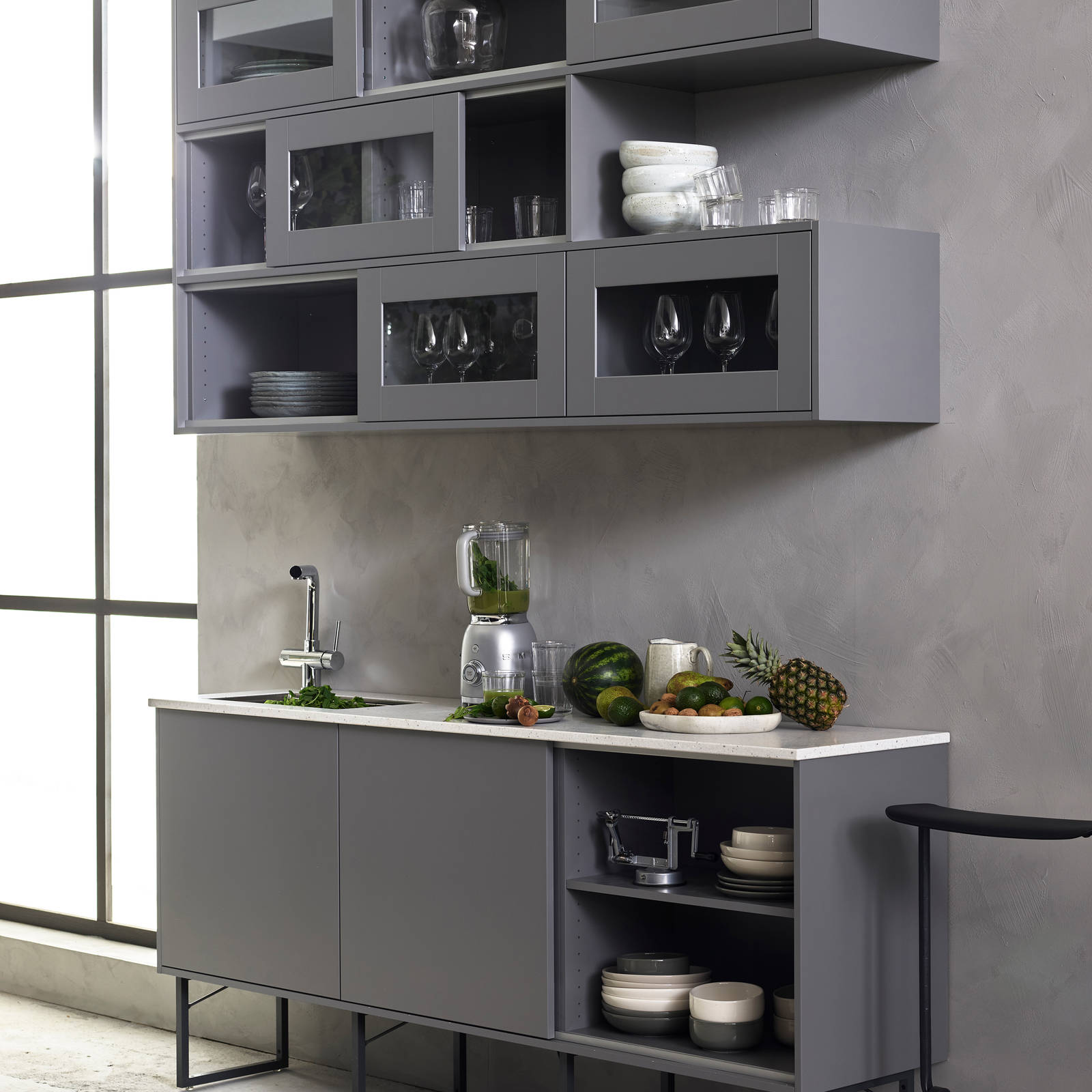 Marbodal Viken Åska - Smart skjutdörrsskena för väggskåpens luckor. Bänkskiva i Corestone på grunda bänkskåp på metallben.