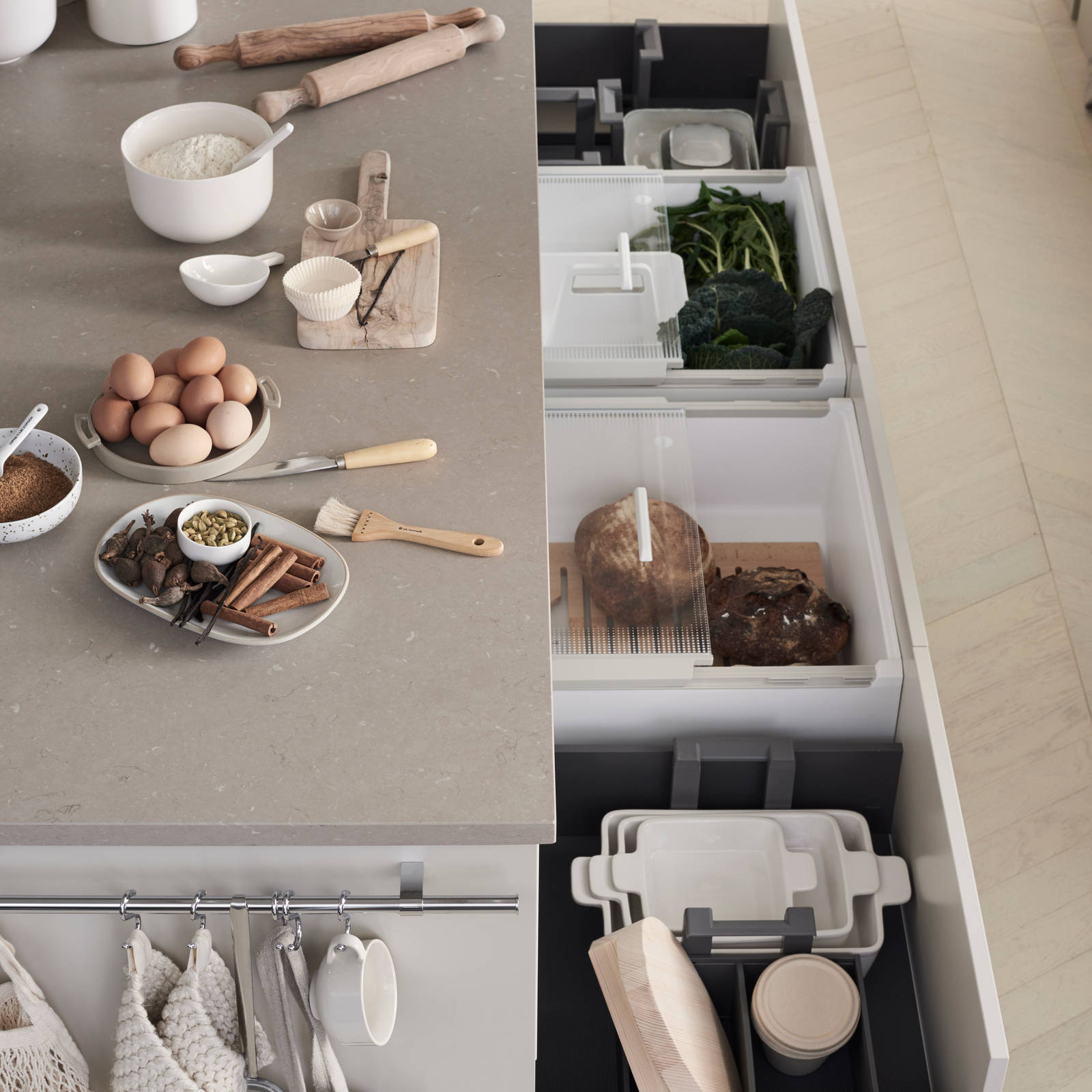 Åpne og uttrekkbare kjøkkenskuffer i det moderne beige kjøkkenet Line fra Sigdal med glatte dører i fargen Korn, samt ingredienser til baking på benken