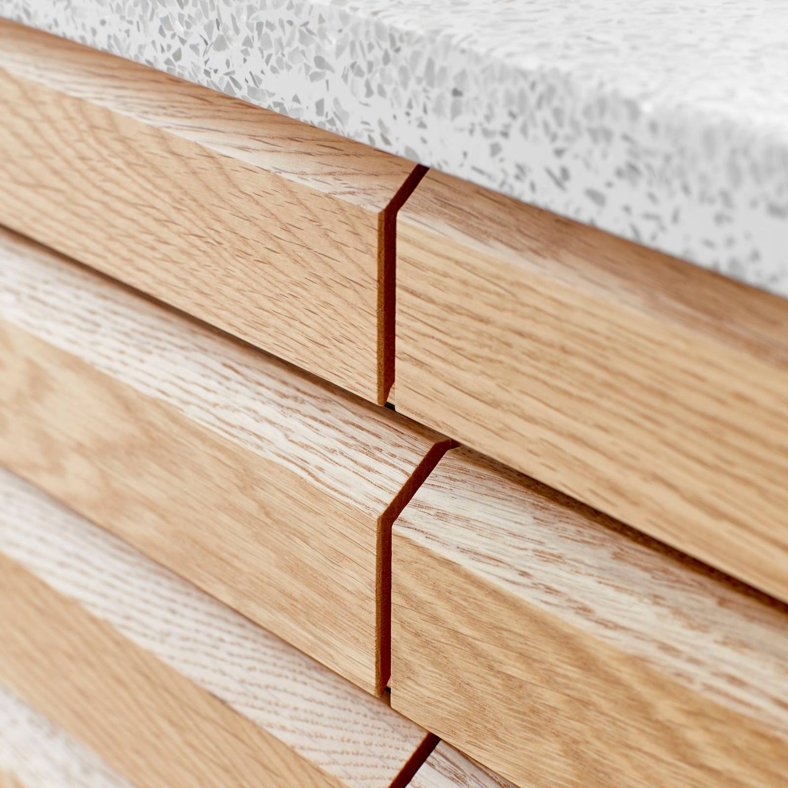 Nærbillede av snedkerbadeværelse Ikon Finér eg mat hvid fra INVITA med håndplukkede, massive egetræslameller med hvid vask