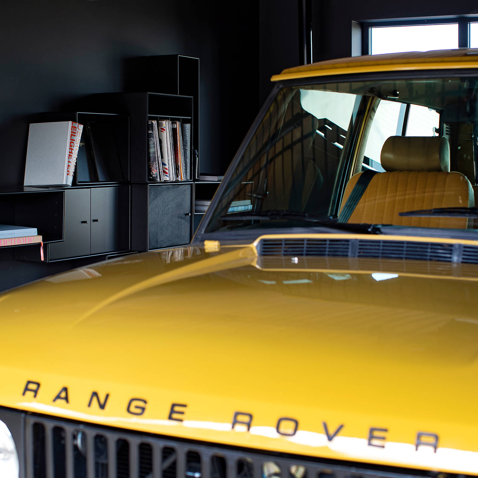 Garagen med sorte Montana reoler og Range Roveren i yndlingsfarven Bahama Gold