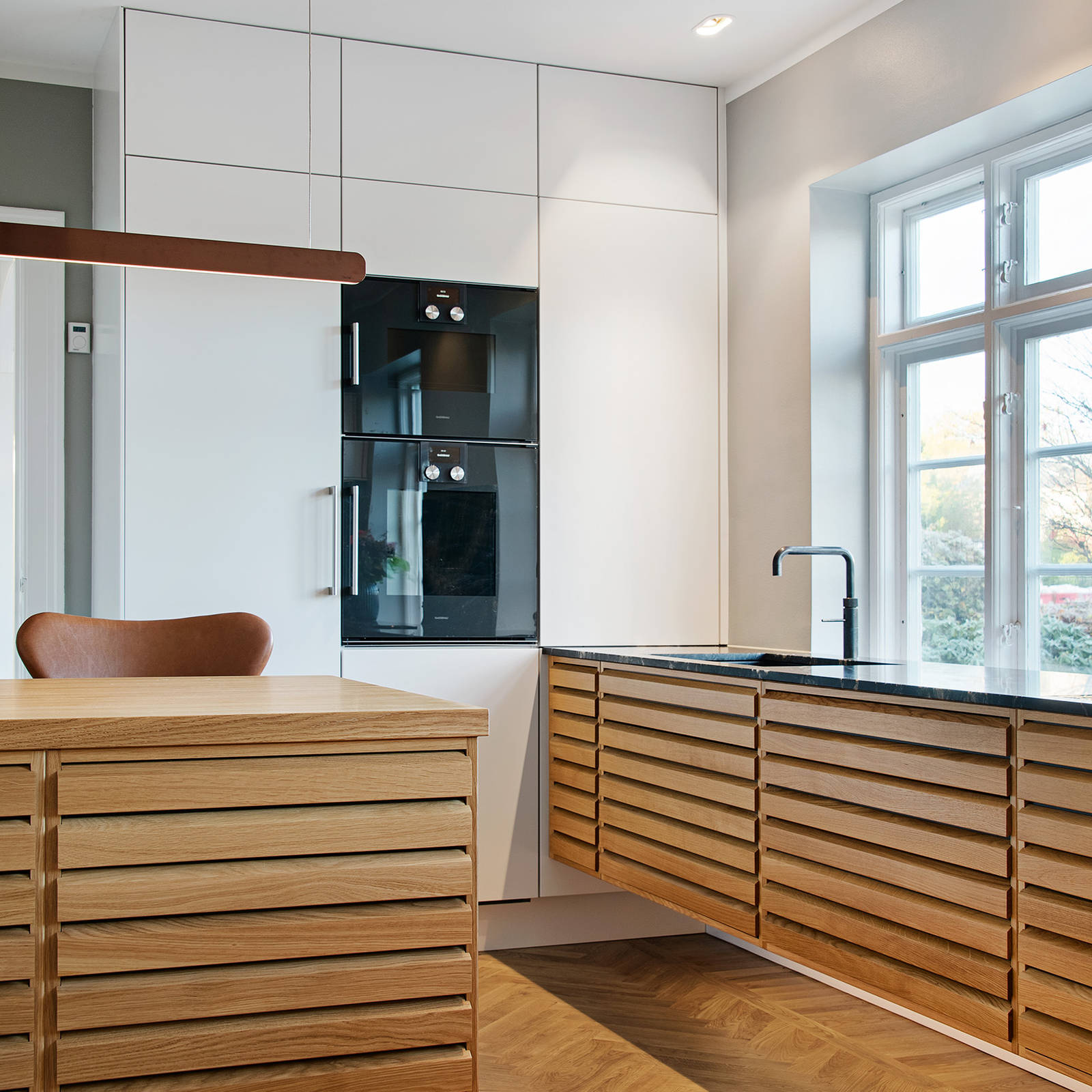 Classic kitchen in oak with white tall cabinets