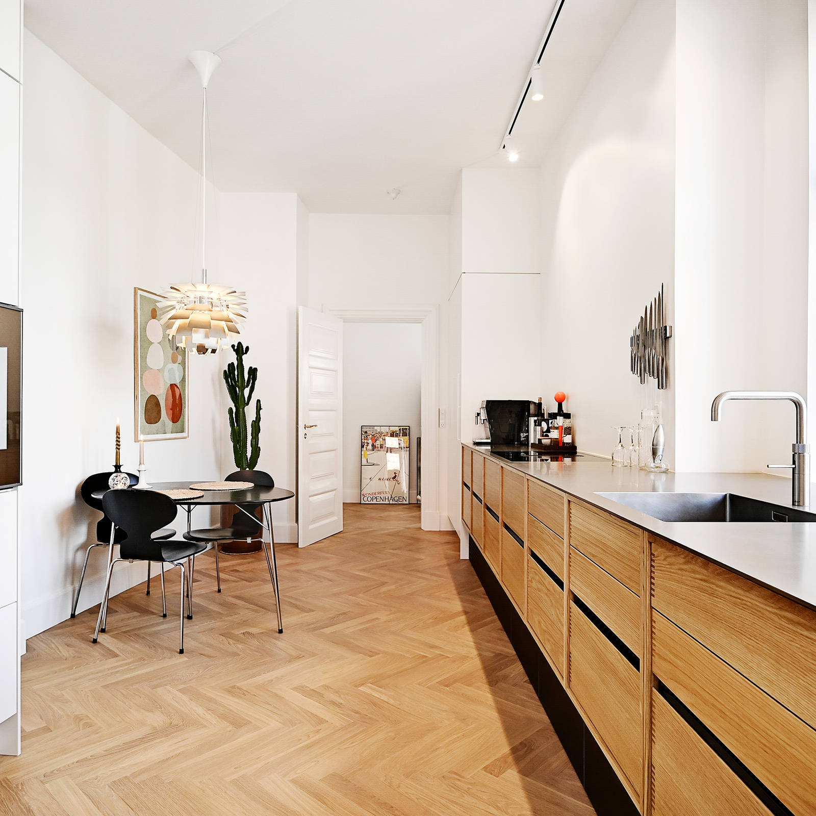 Kjøkken i eik med sort sokkel og bordplate i curlet stål