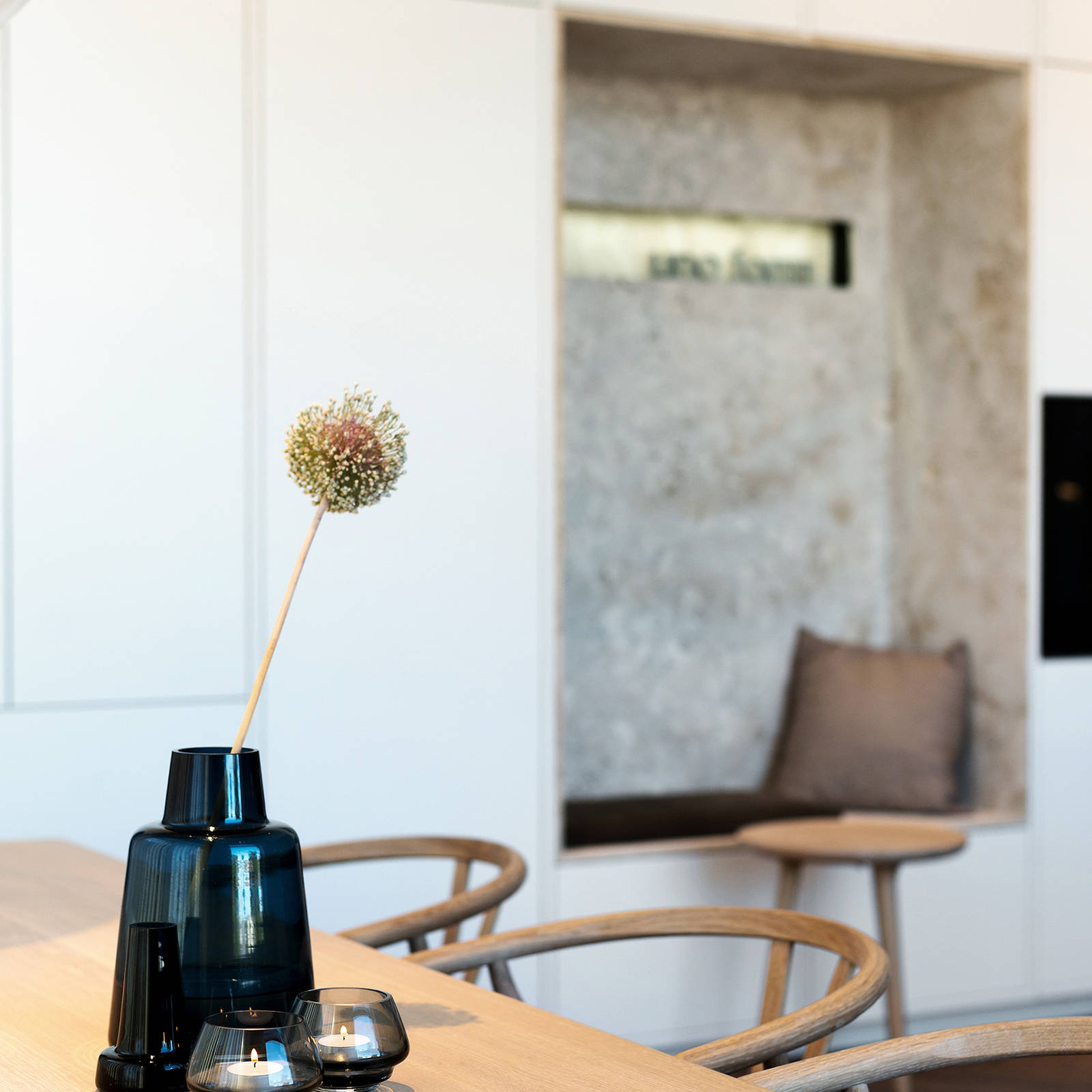 Matbord med y-stolar och vit högskåpvägg med alkov och skräddarsydd läderkudde