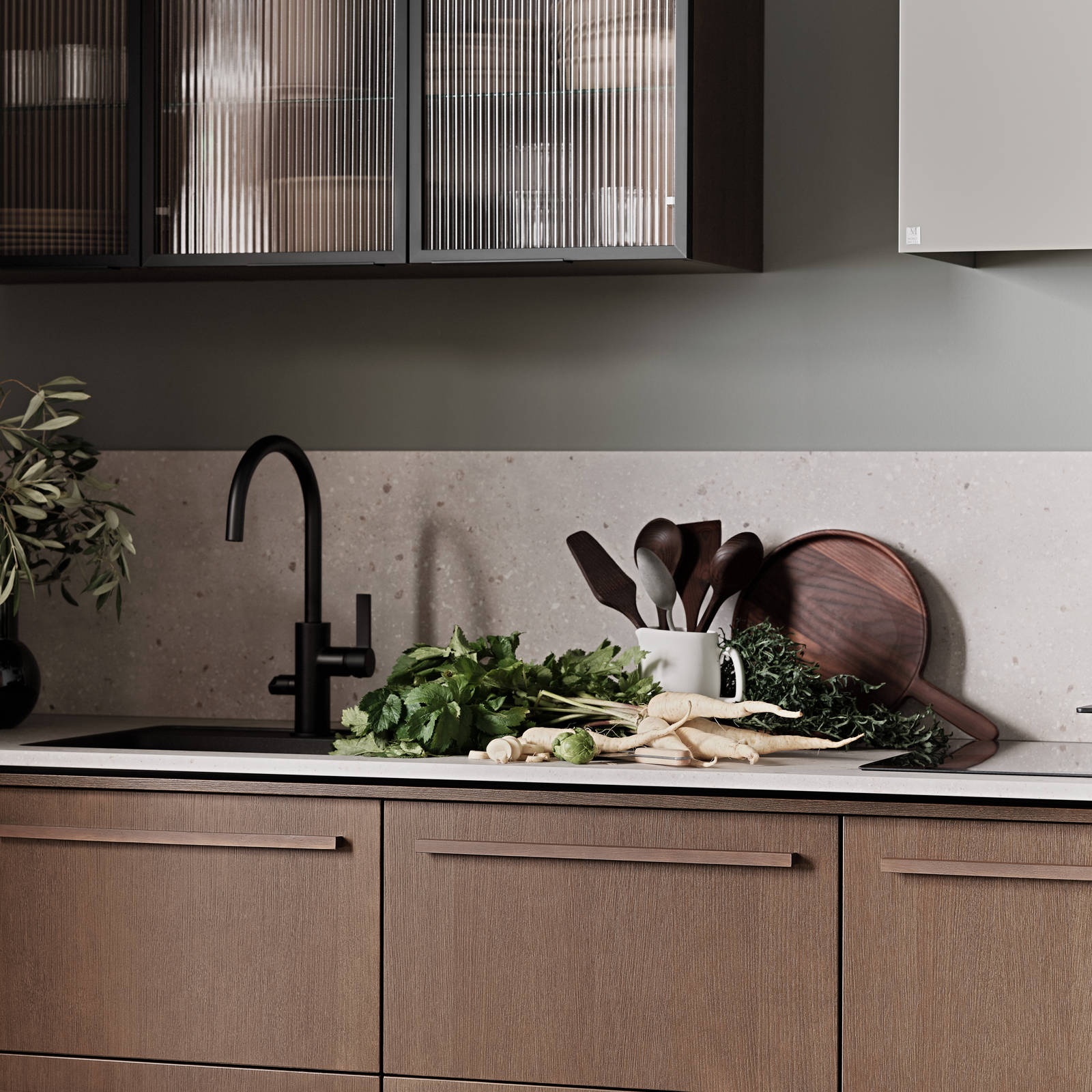 Nærbillede af Køkken Forever Oak fra INVITA, mørk eg køkkenskabe med massiv tre mørk eg håndtag, komposit bordplade, sort armatur og vitrineskab med riflede glas i tynd, sort aluminiumsramme