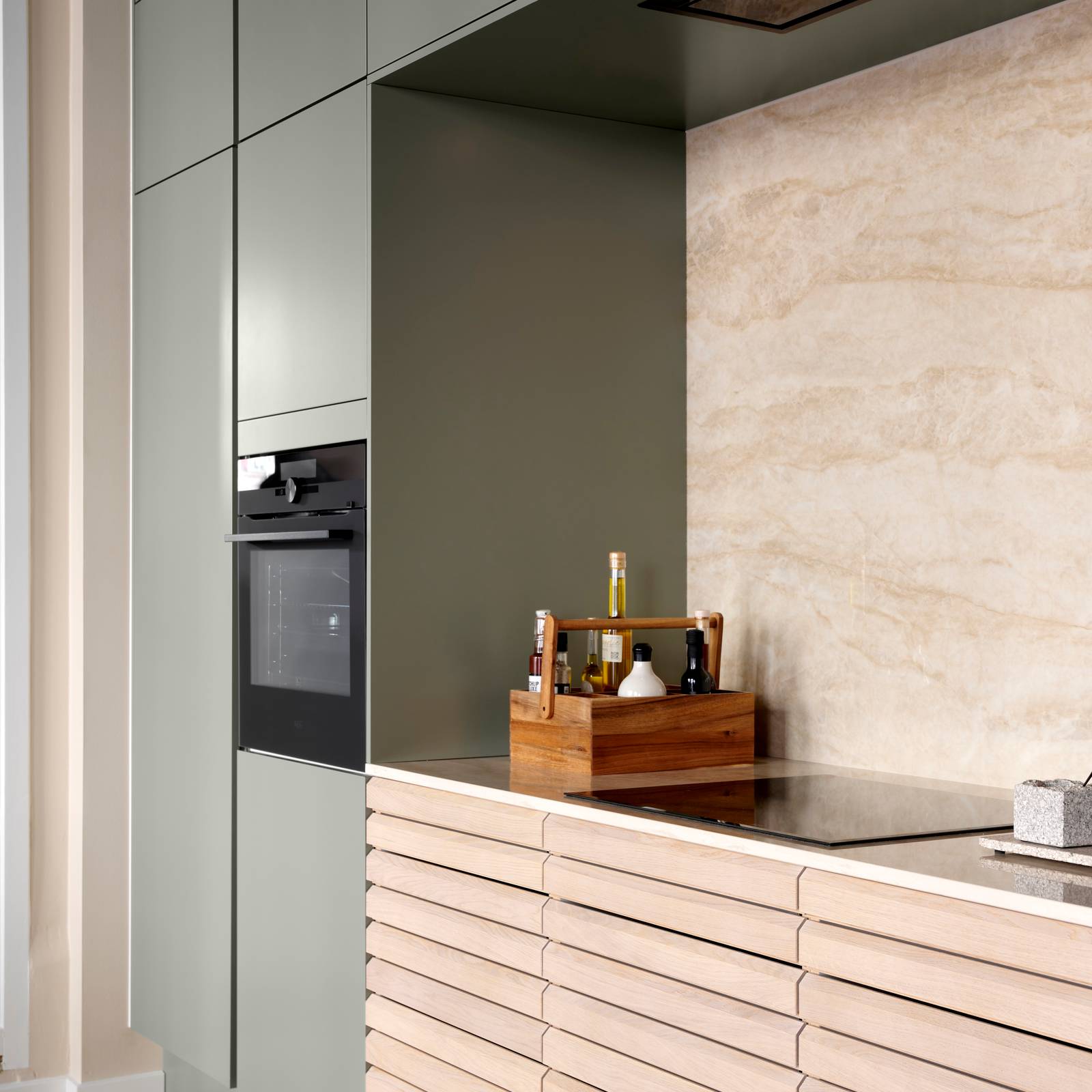 grebsfrie grønne køkkenet Highline Salvie med indfræsede greb i lågerne fra INVITA kombineret med med af egetræskøkken Ikon med håndsorterede lameller i massiv eg.