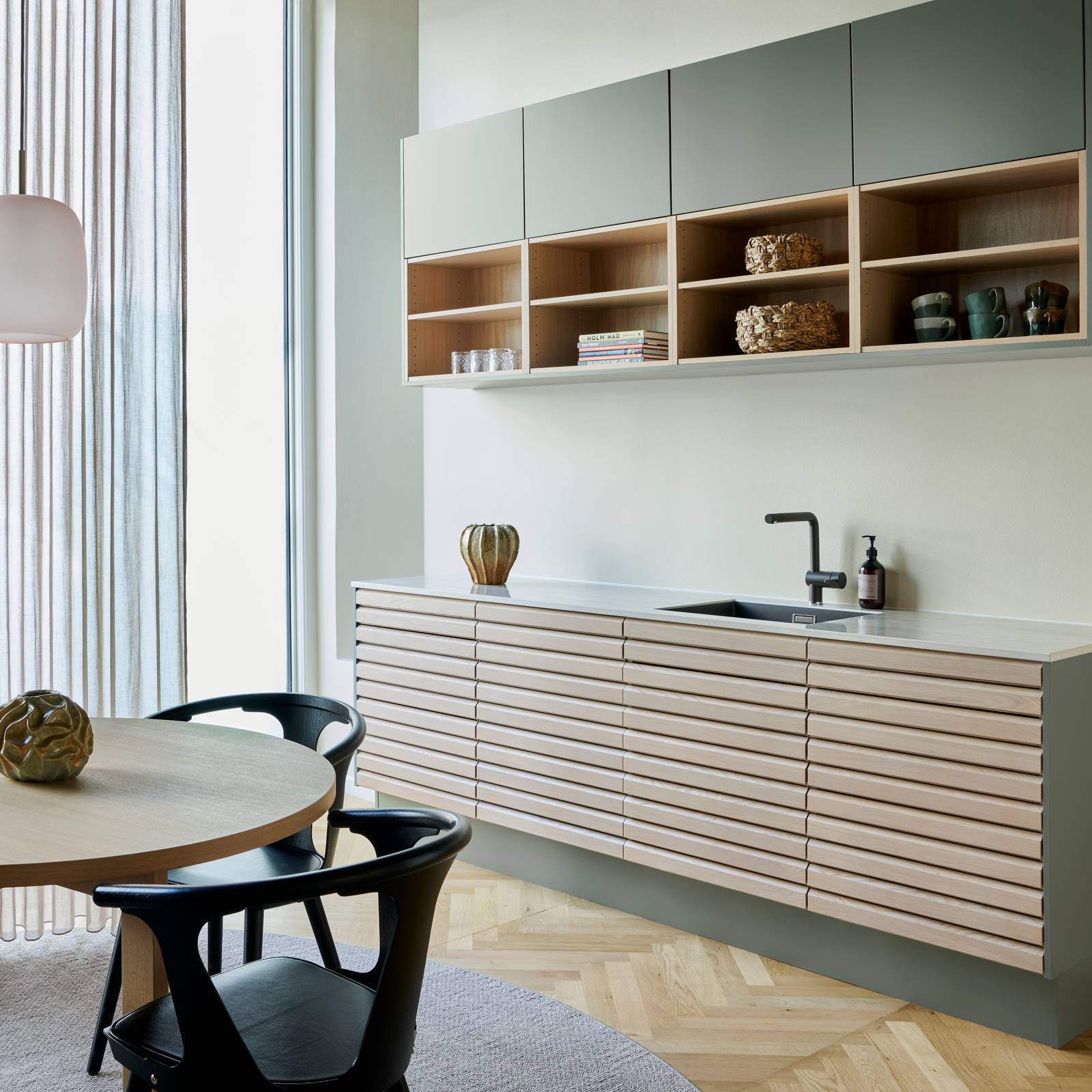 Egetræskøkken Ikon med håndsorterede lameller i massiv eg, kombineret med overskabe og åbne væghylder grebsfrie grønne køkkenet Highline Salvie med indfræsede greb i lågerne fra INVITA