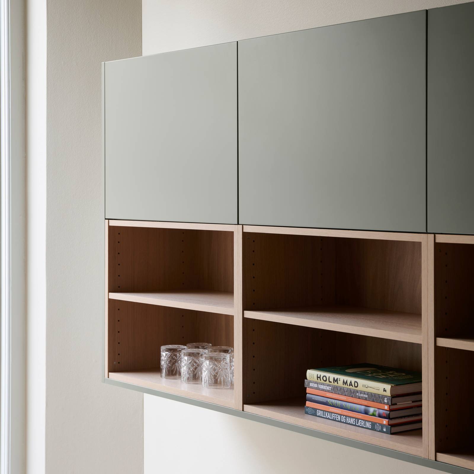 Nærbillede af åbne væghylder og overskabe i grebsfrie grønne køkkenet Highline Salvie med indfræsede greb i lågerne fra INVITA