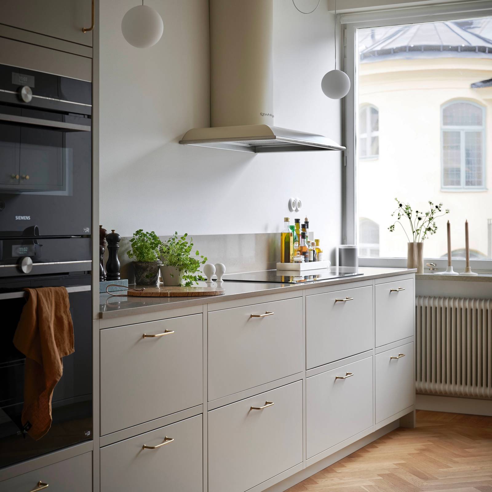 Forrammekøkken Athena Fusion i lys grå farve Sky fra INVITA med grå stein bordplade, rustfrit stål håndtag