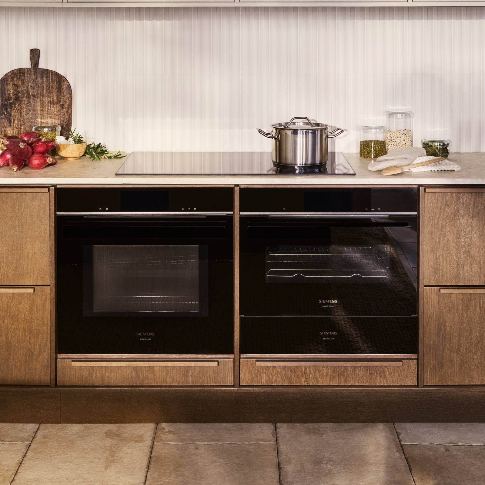 Mørk eg køkkenbænk Forever Oak fra INVITA kombineret med overskaber Athena Sand, hvide fliser, bordplade og massiv ek håndtag, ovn og dampovn fra Siemens