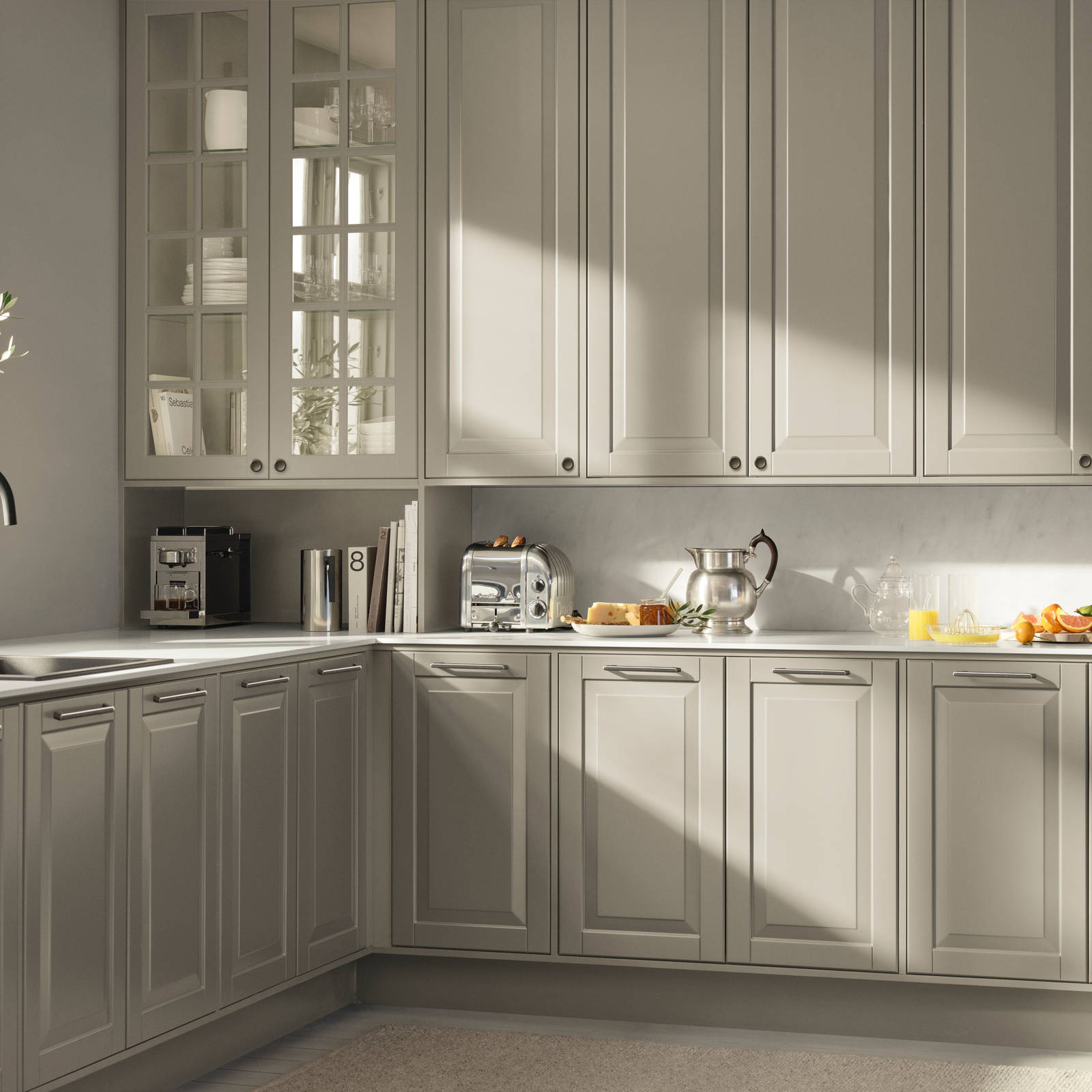 Beige landkøkken Nordic Sand fra INVITA med fyldningslåger, sort håndtag, vitrineskab med sprosselåger og hvid marmor laminatbordplade