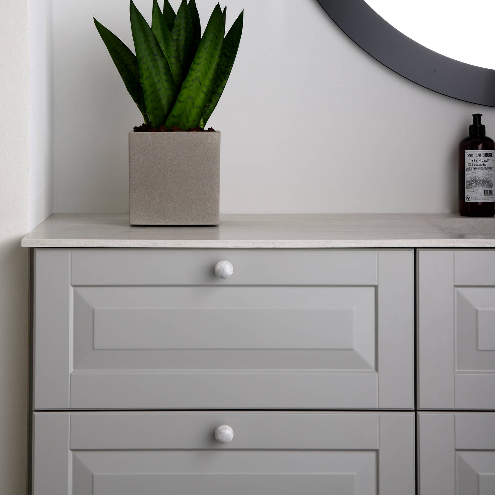 Romantisk badeværelse Nordic i lys grå farve Sky fra INVITA med klassiske detaljer som fyldniner og glaslåger med sprosser, marmor håndtag og sort armatur