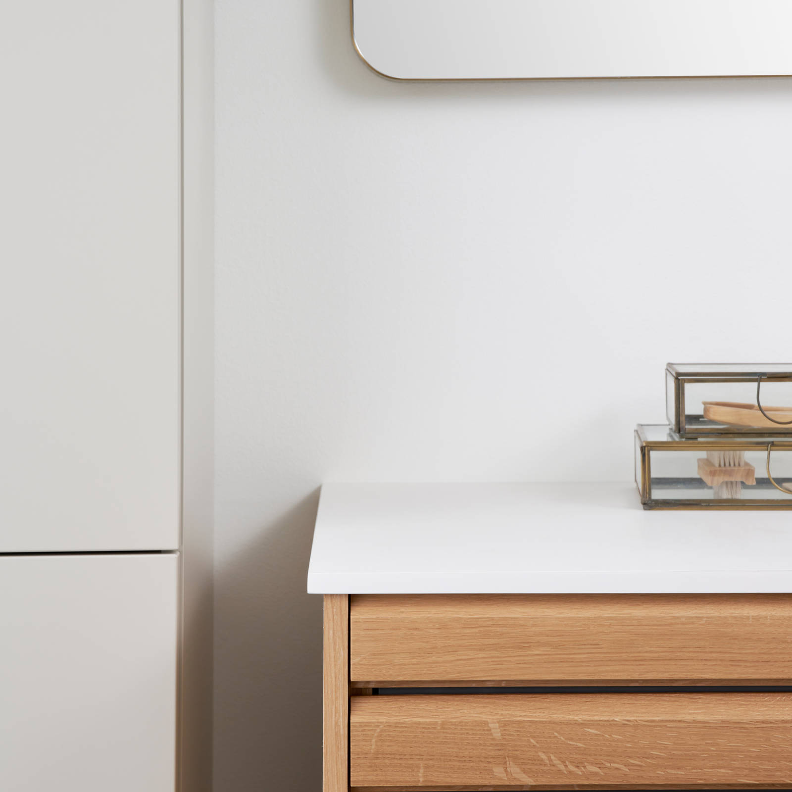 Nærbillede af hjørne i snedkerbadeværelse Ikon Finér eg natur fra INVITA med håndplukkede, massive egetræslameller med hvid vask