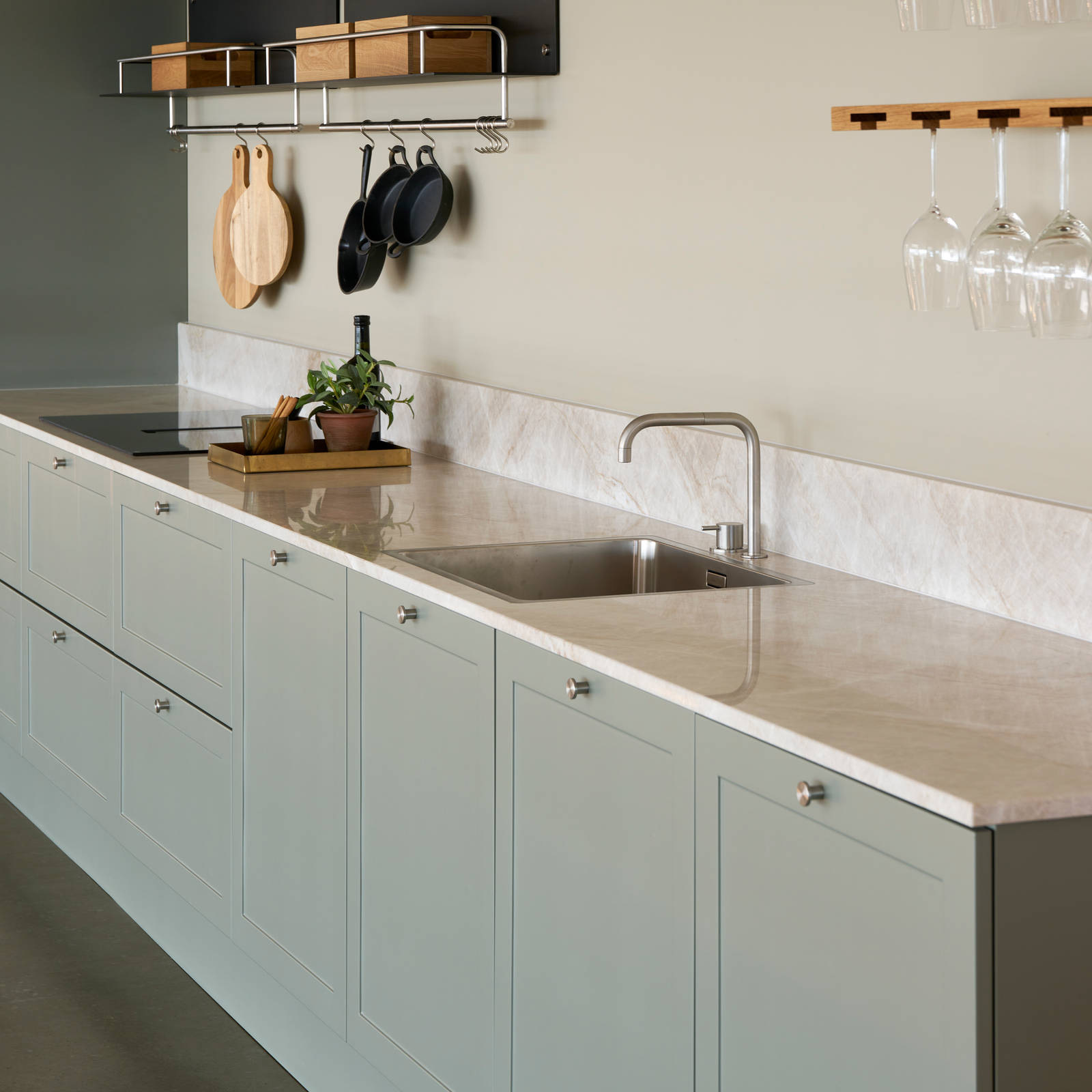 Grønn højskabe retrokøkken Square Salvie køkken fra INVITA med rustfri stål håndtag, armatur og vask med grå marmor bordplade