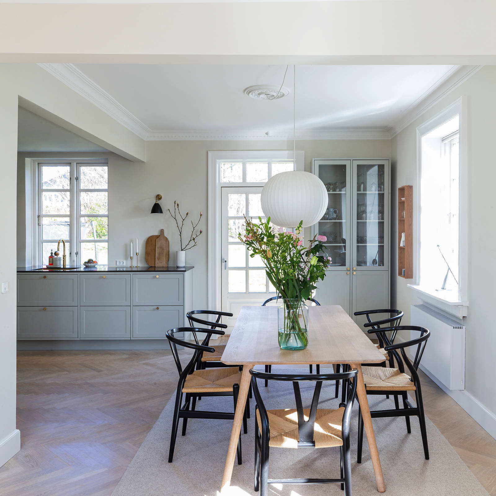 Et lysegråt Shaker-køkken fra uno form med plads til familiehygge, børnefødselsdage og juleaftener med mere end 20 gæster rundt om spisebordet