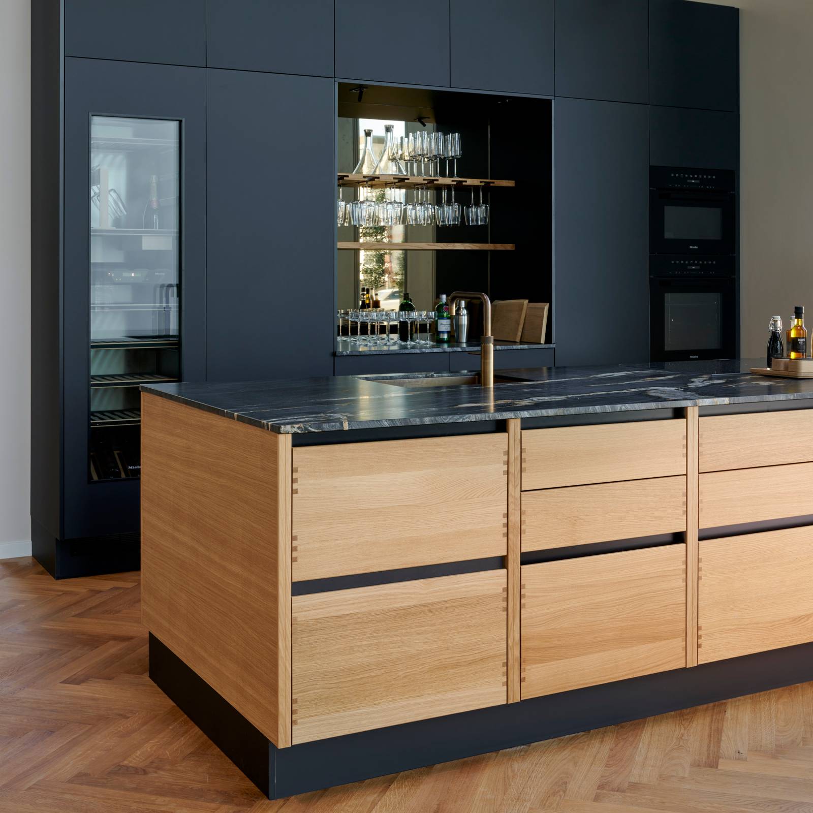 Køkkenøya Glød fra INVITA , skuffer i massivt egetræ med fingertappede samlinger og sort granit bordplade