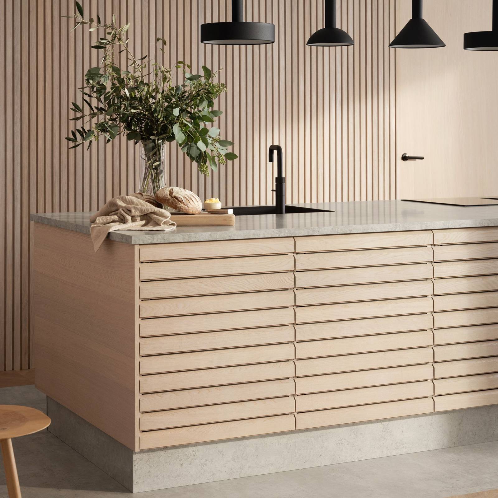 Nærbillede af egetræskøkkenø Ikon fra INVITA med håndsorterede lameller i massiv eg, mat sort armatur og sorte lamper