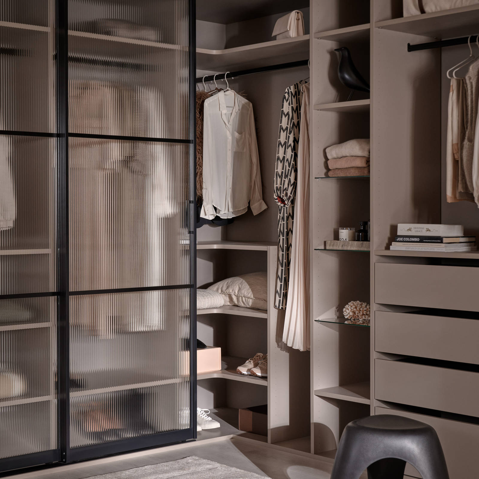 Walk-in garderobe med glasskydedøre med sort metalramme