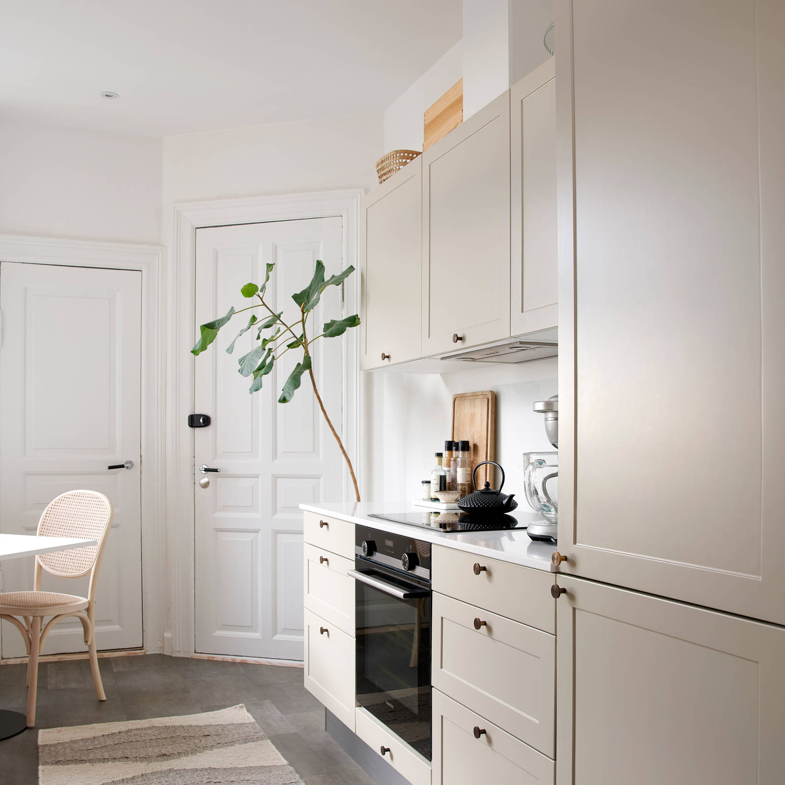 Beige retrokøkken Square Sand køkken fra INVITA med messing håndtag, hvid bordplade