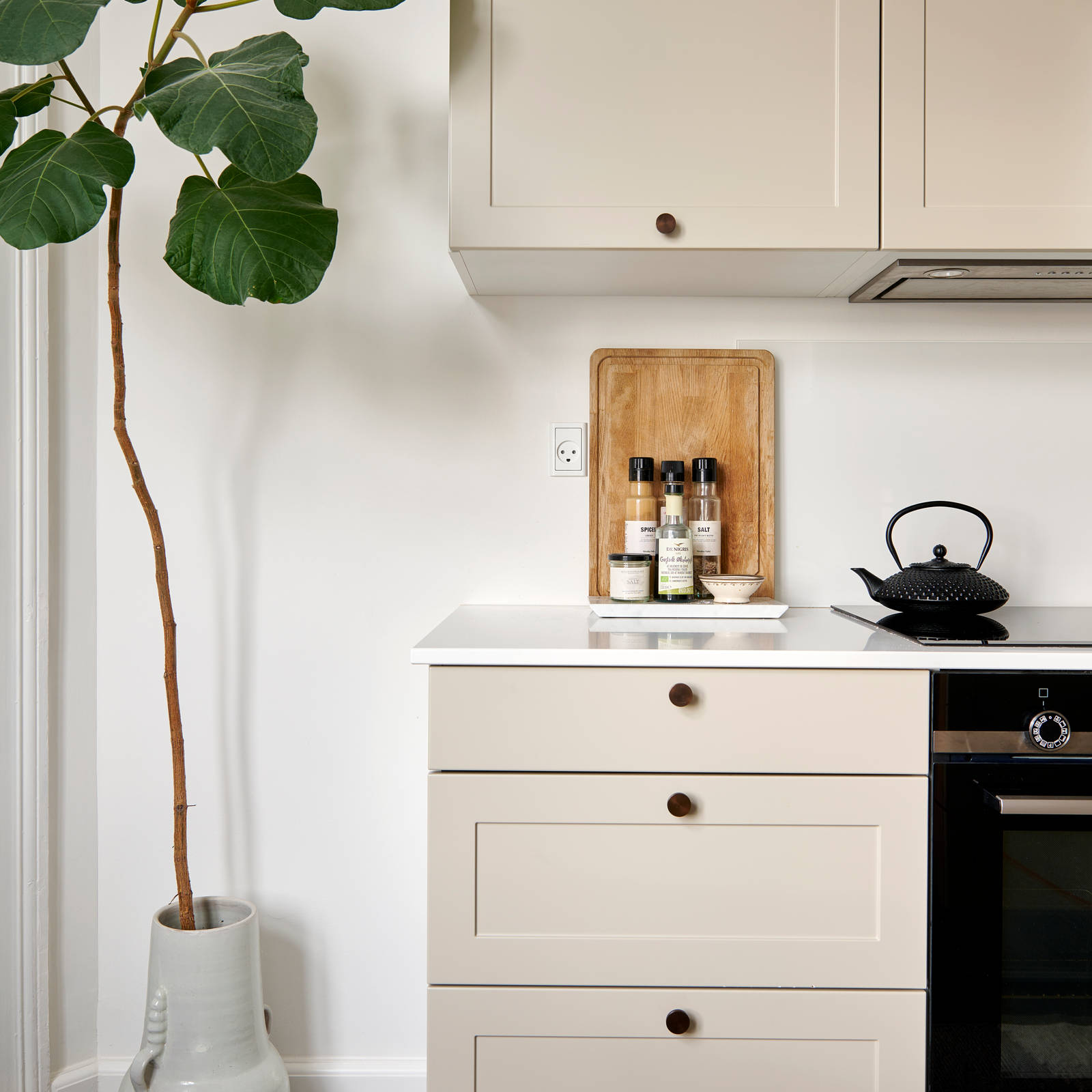 Beige retrokøkken Square Sand køkken fra INVITA med messing håndtag, hvid bordplade