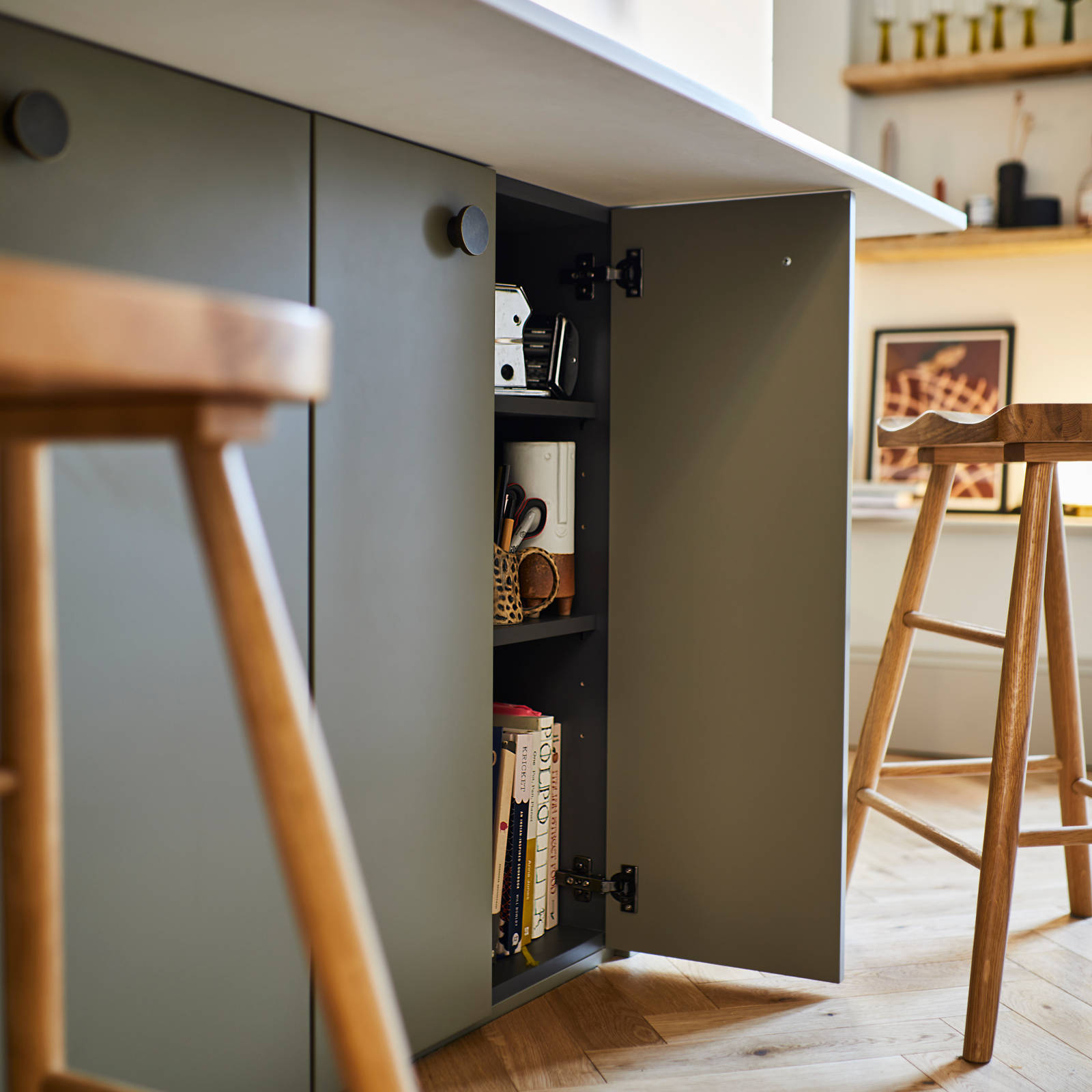 Close-up of opened cabinet in Soho Balmoral kitchen island, with light wood barstools