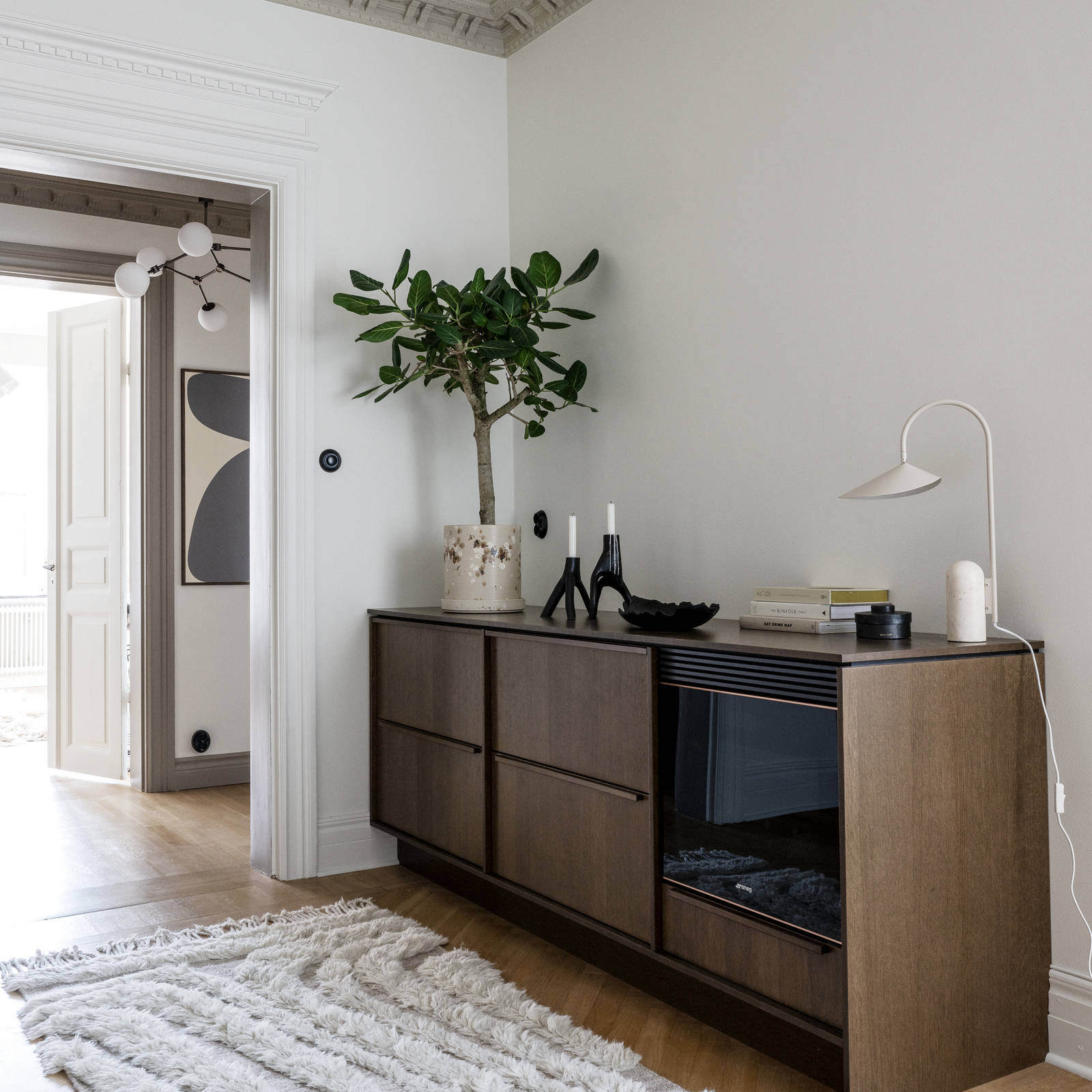 Benkskap med møbelaktig preg som en skjenk med innebygget vinkjøler, i Favn brunbeiset eikefiner med matchende håndtak.