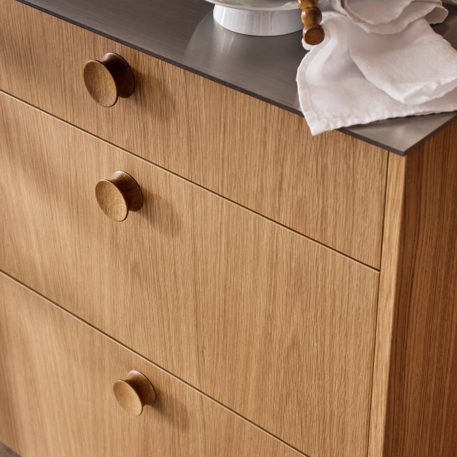 Nærbillede af køkkenlåger eg med eg greb på Jubilæumskøkken fra INVITA med elegant træfinér eg