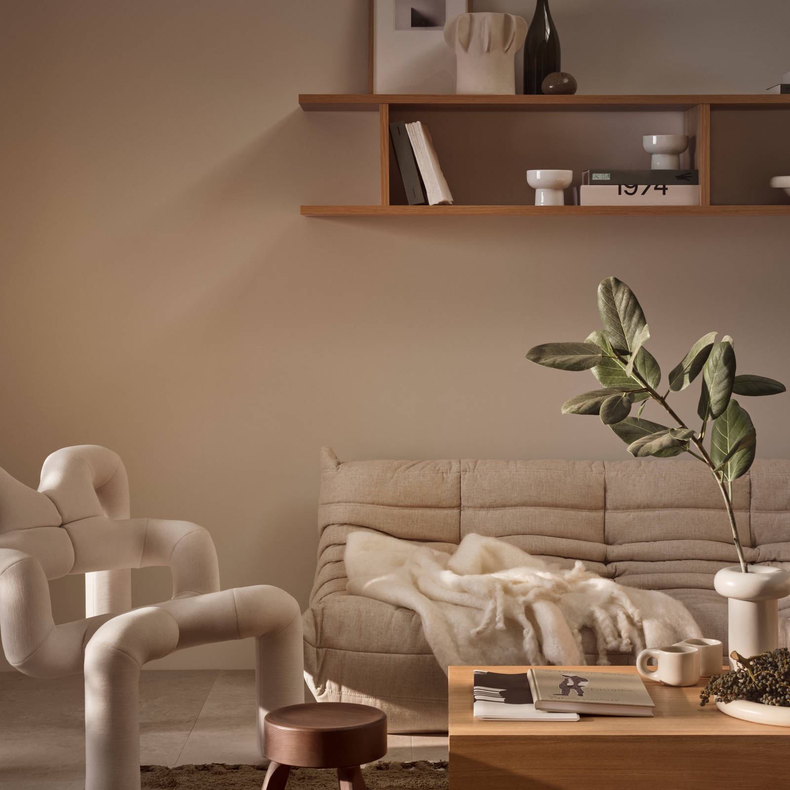 Stue med beige sofa og INVITA-kataloger på sofabordet i egetræ