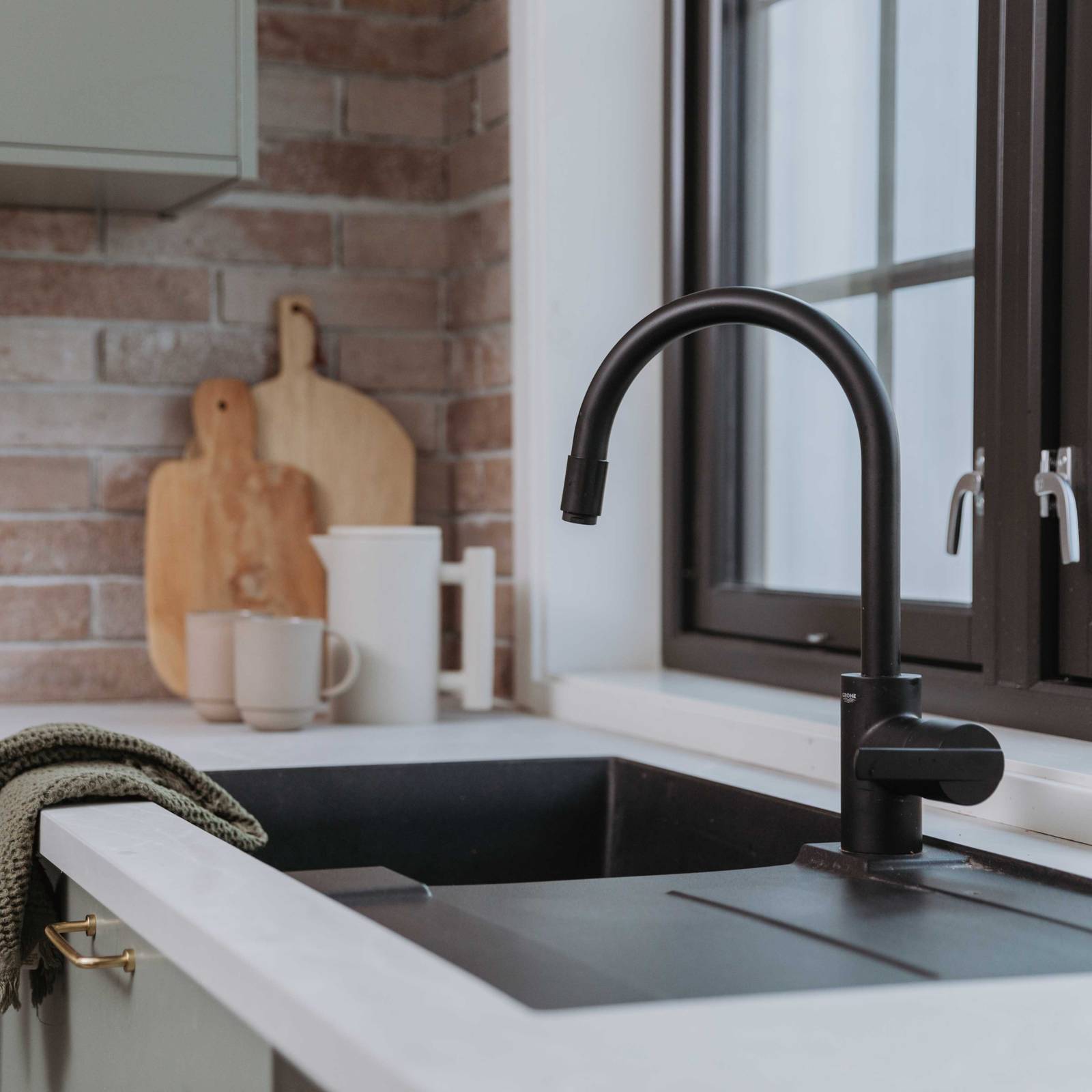 Sort armatur og sort vask i Stine Hartmanns Uno Furu kjøkken fra Sigdal med laminat Kandia marmor og teglstein-flis