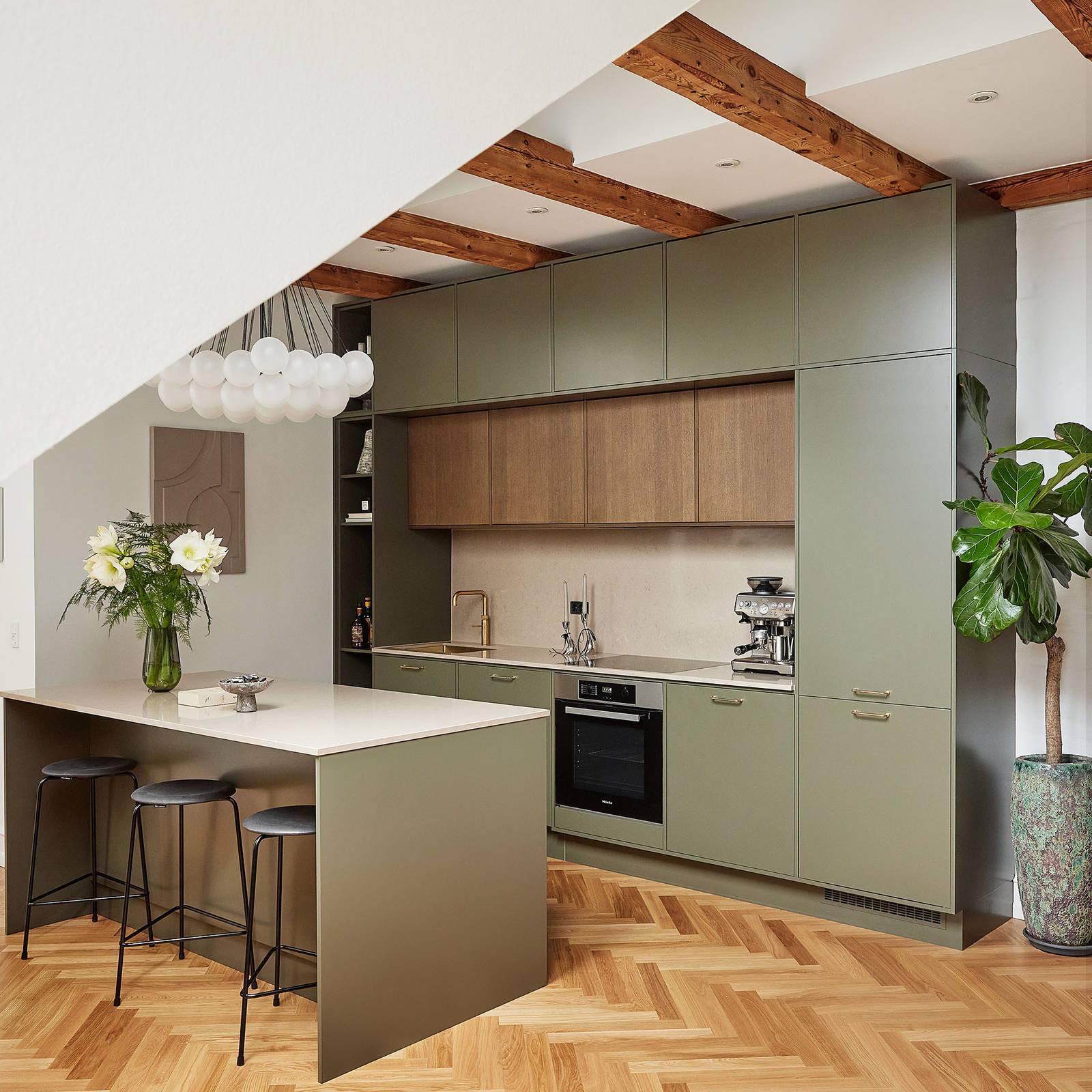 Grønt køkken med træskabe og køkkenø