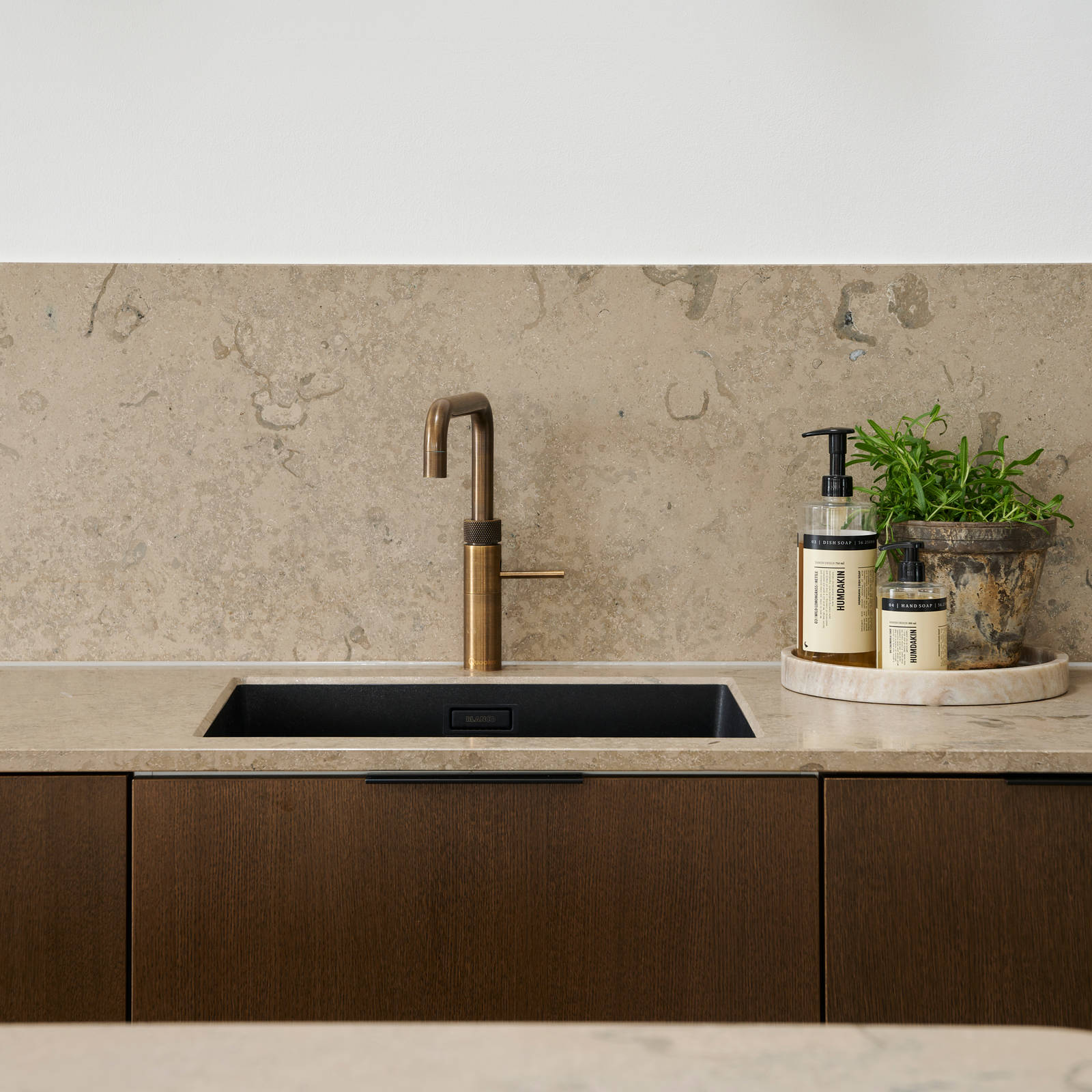 Forever Oak køkken med mørke træ fronter, marmor bordplade og splashback, sort vask og messing armatur