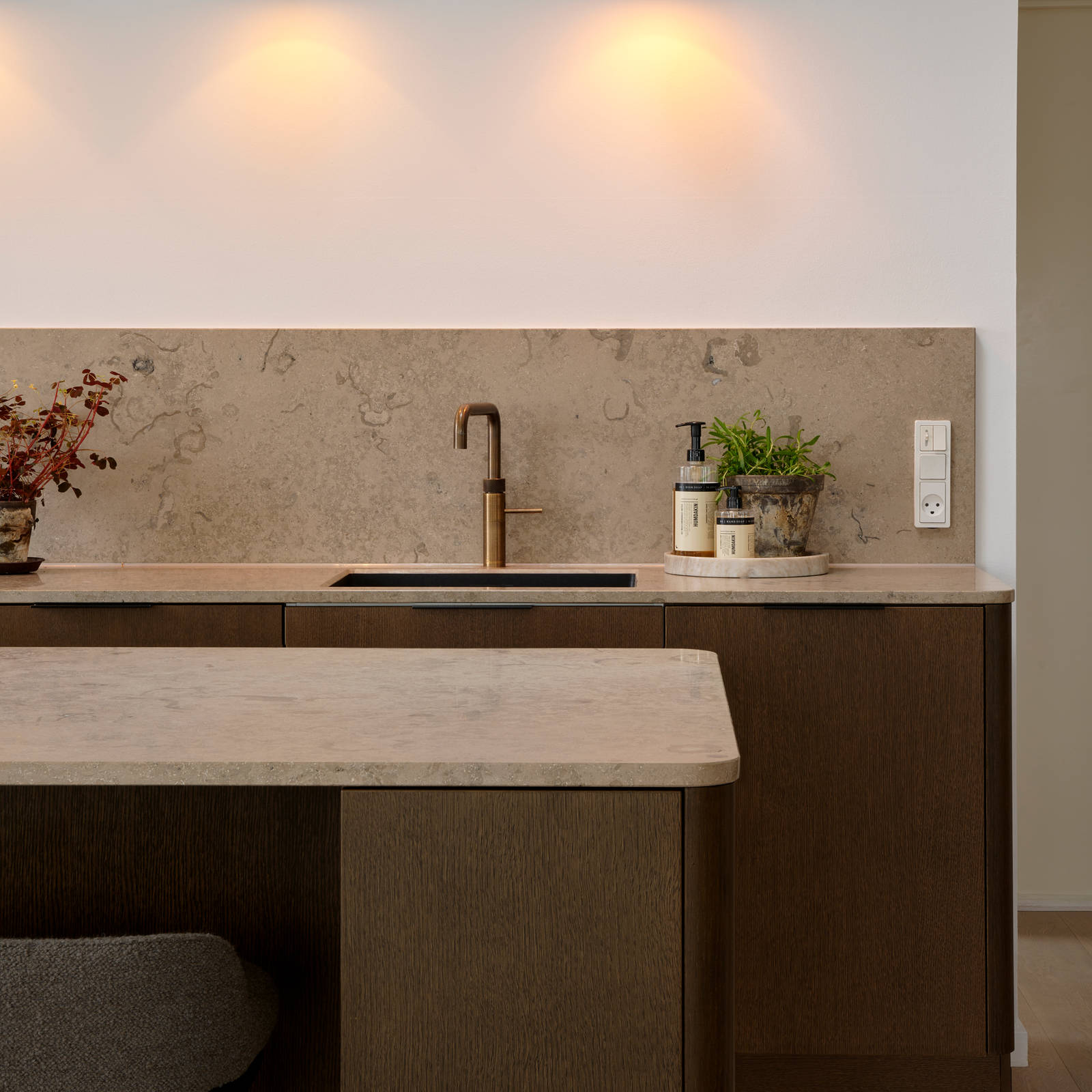 Forever Oak køkken med mørke træ fronter, marmor bordplade og splashback, sort vask og messing armatur