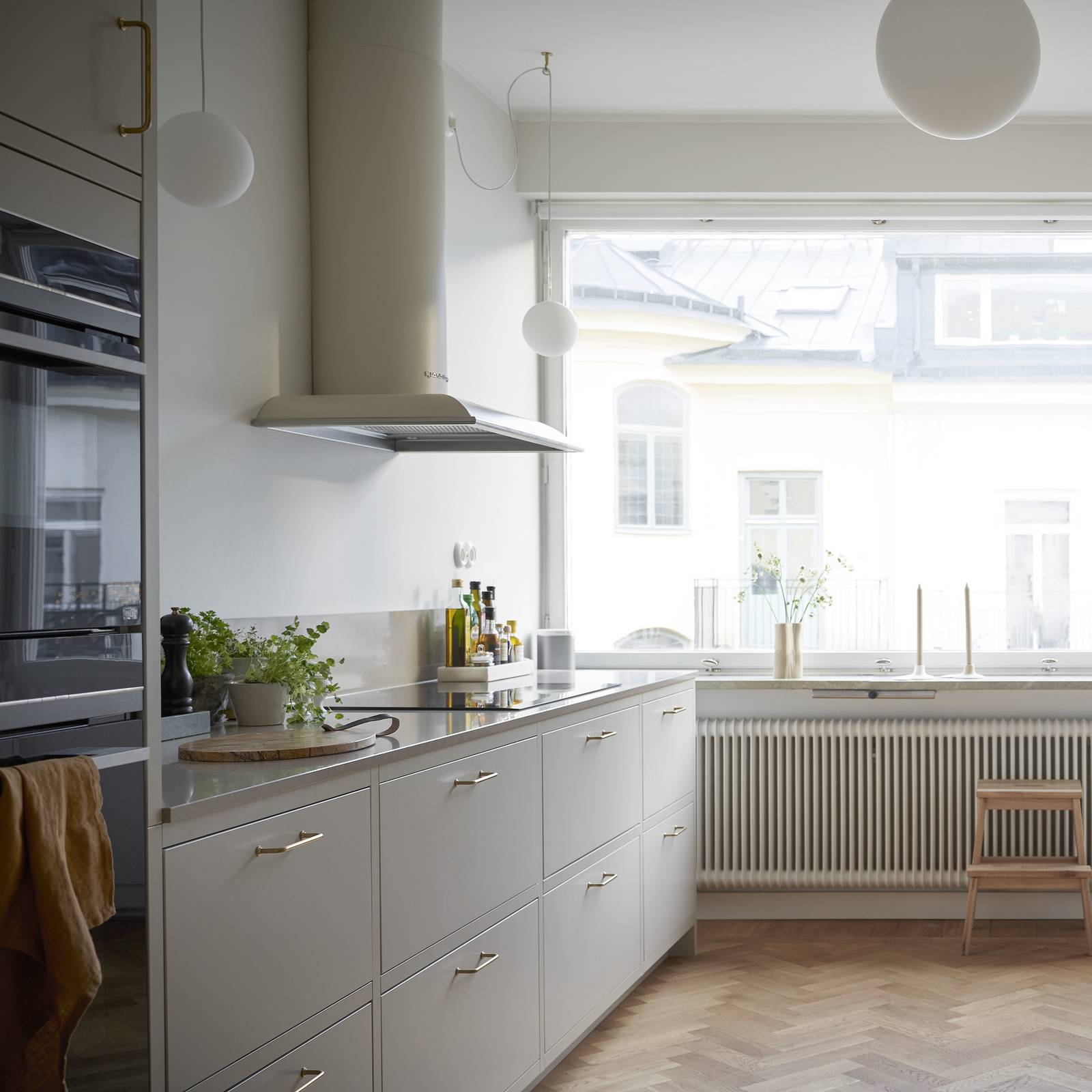 Forrammekøkken Athena Fusion i lys grå farve Sky fra INVITA med grå stein bordplade, rustfrit stål håndtag