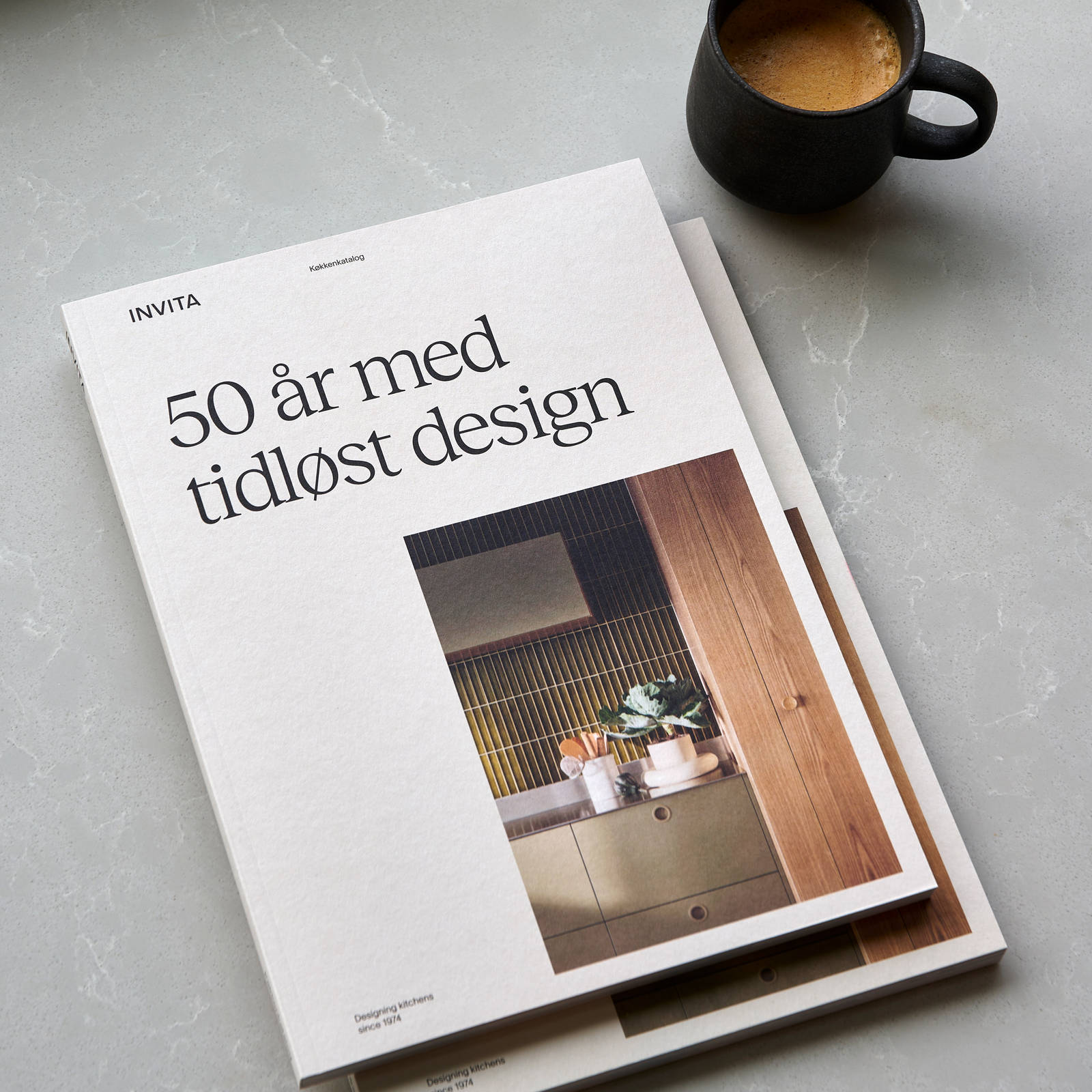 Katalog fra INVITA og kaffekop på bordet