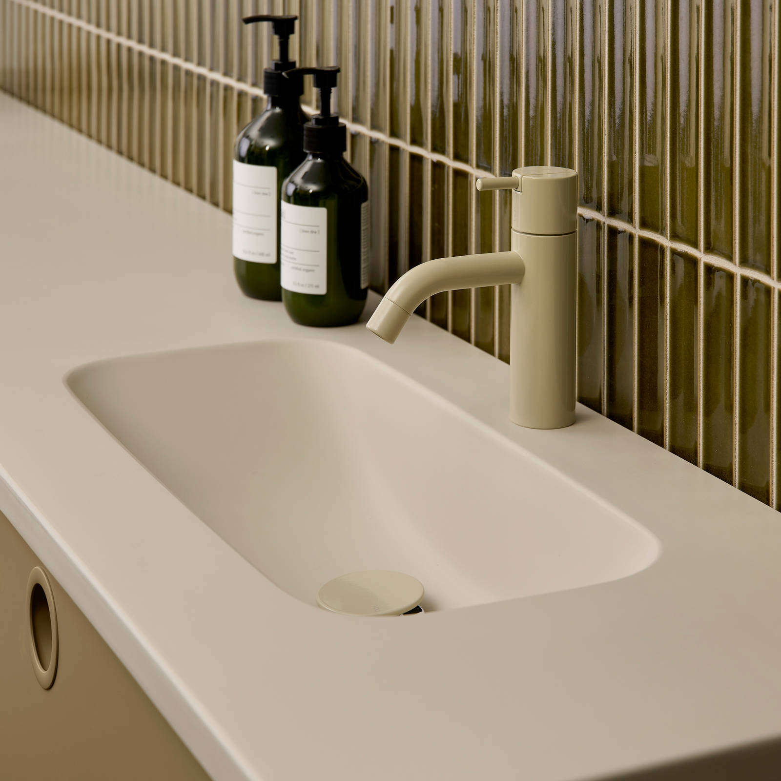 Nærbillede av vask og armatur i Jubilæumsbad fra INVITA med grønne skaber inspireret av 1970'erne, og grønne fliser