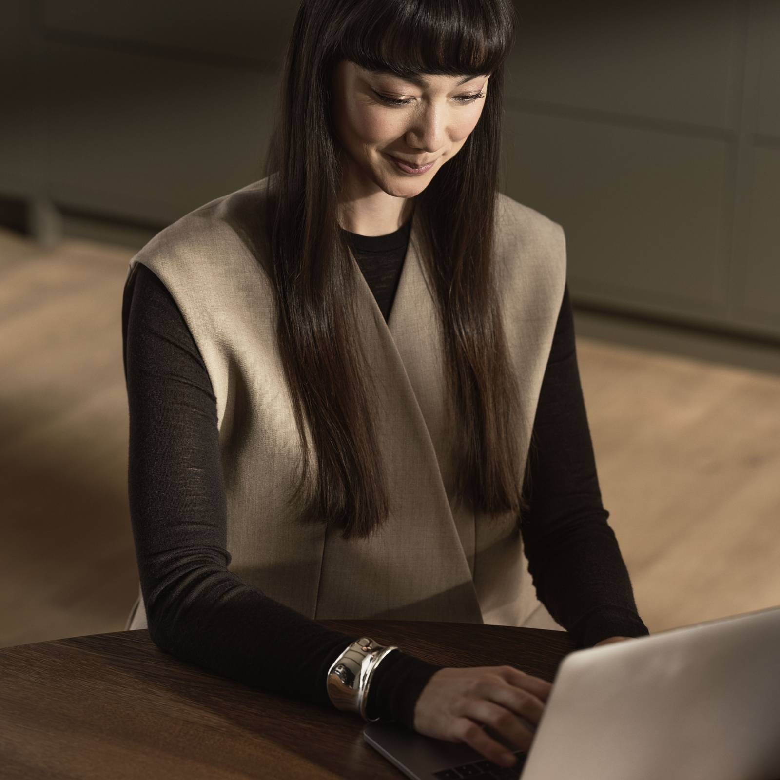 Kvinna i Warm Minimalism-kök sitter vid en laptop.