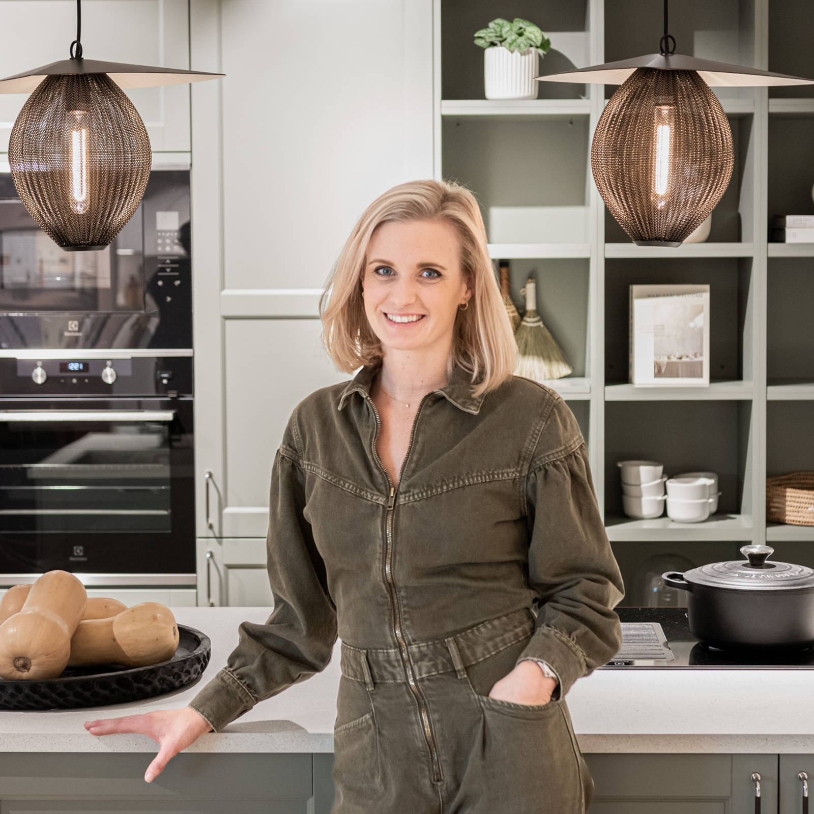 Köksdesigner Cassandra vid köksö i grönt shakerkök i Marbodals butik