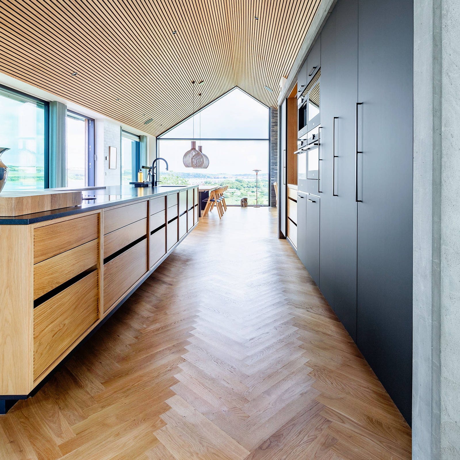 Stor kjøkkenøy fra uno forms Copenhagen-kolleksjon i eik og høyskap i matt svart laminat.