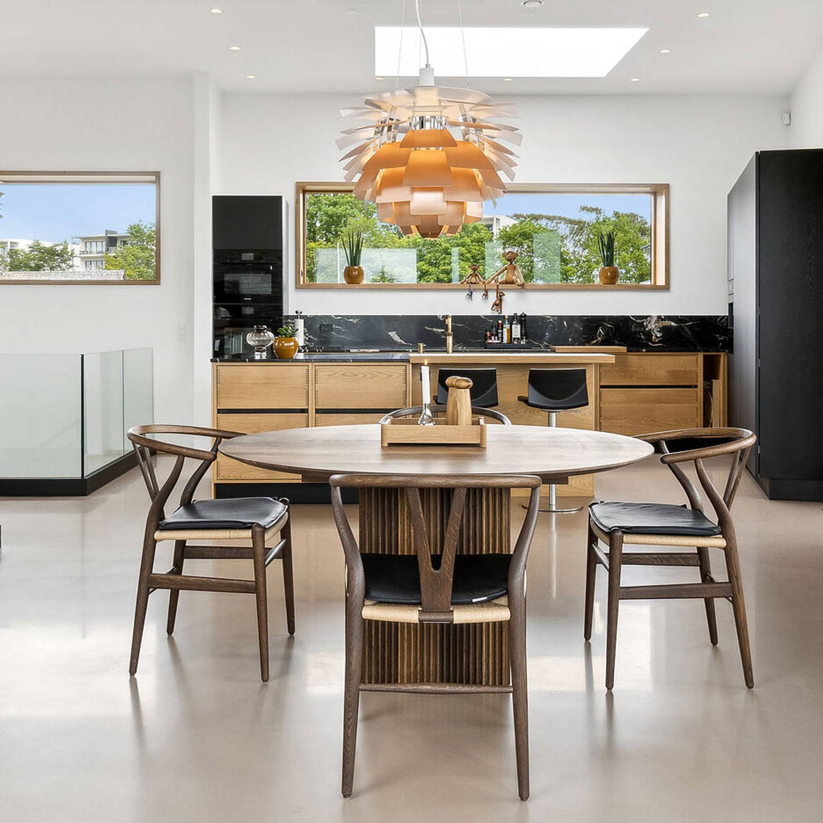 Køkken og spisestue er indrettet med danske designklassikere fra uno form, Louis Poulsen og Carl Hansen.