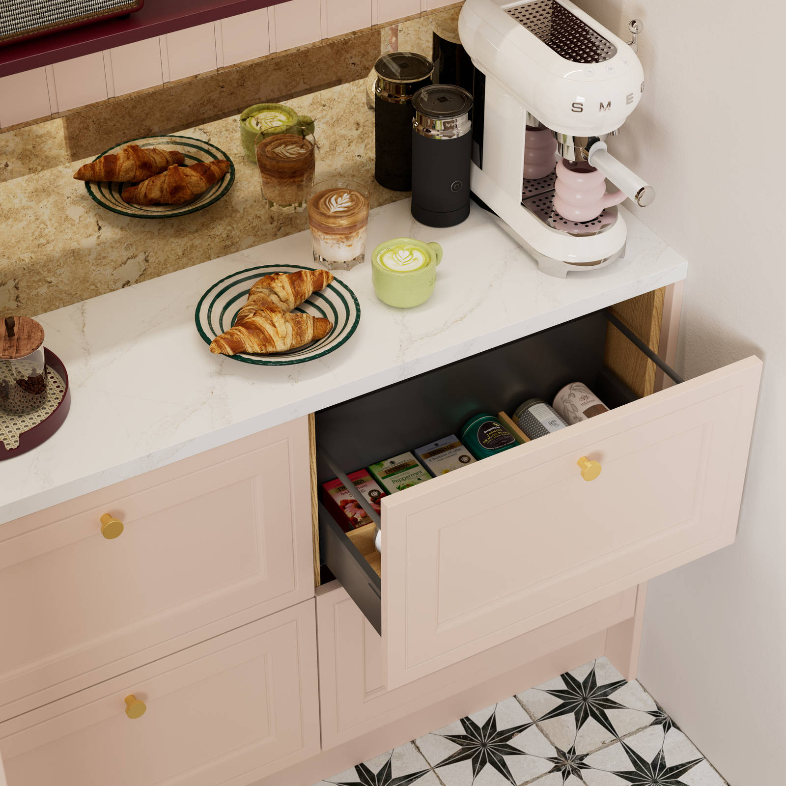 Opened drawer of teas in painted wood grain Shaker style Bewdley cabinets in light pink shade Chalk Blush, with marbled worktop, brass knobs and Smeg coffee machine on countertop.