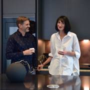 Anna and Andrew each holding a cup of coffee in their dark and decadent handleless Integra Soho Charcoals from Magnet.