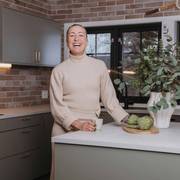 Stine Hartmann ved køkkenøya i kjøkkenet Uno Furu fra Sigdal, kombinert kjøkken og praktisk arbeidsrom