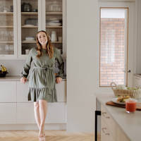 Anni Ihamäki toimivassa melamiini- ja laminaattikeittiössä Hiekassa ja lämminsävyinen vaalea tammimelamiini Novartilta, vitriinikaapeilla ja Quartz-tasolla