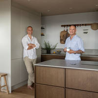 Knut og Kjartan i kjøkkenet fra Sigdal, Favn Nøtt kjøkkenøy med koketopp, høyskap Line Kalkgrå.