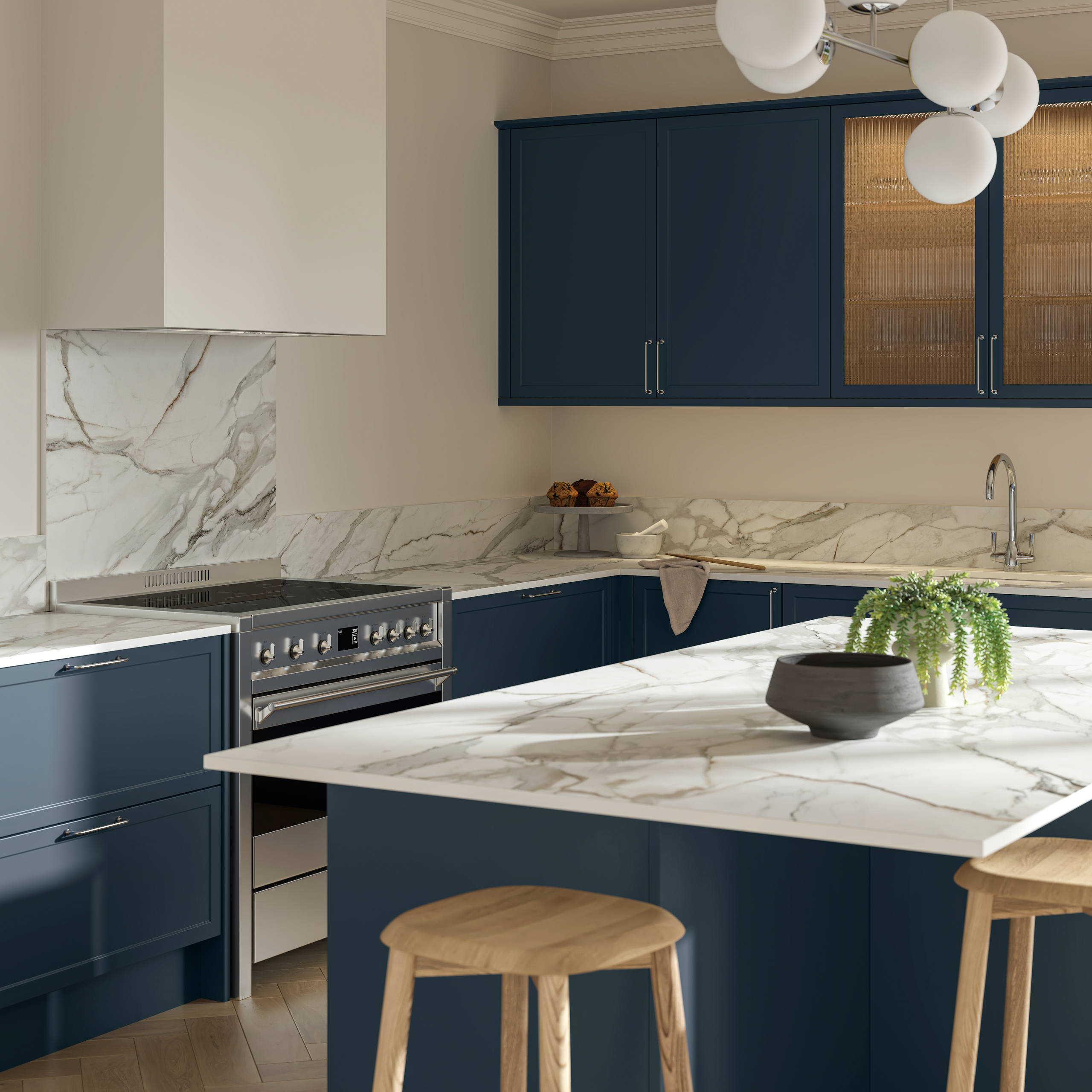 View over kitchen island breakfast bar in modern Shaker kitchen Brunswick Voyage blue with white and grey marbled worktop and matching splashback, and vitrine cabinets with fluted glass.