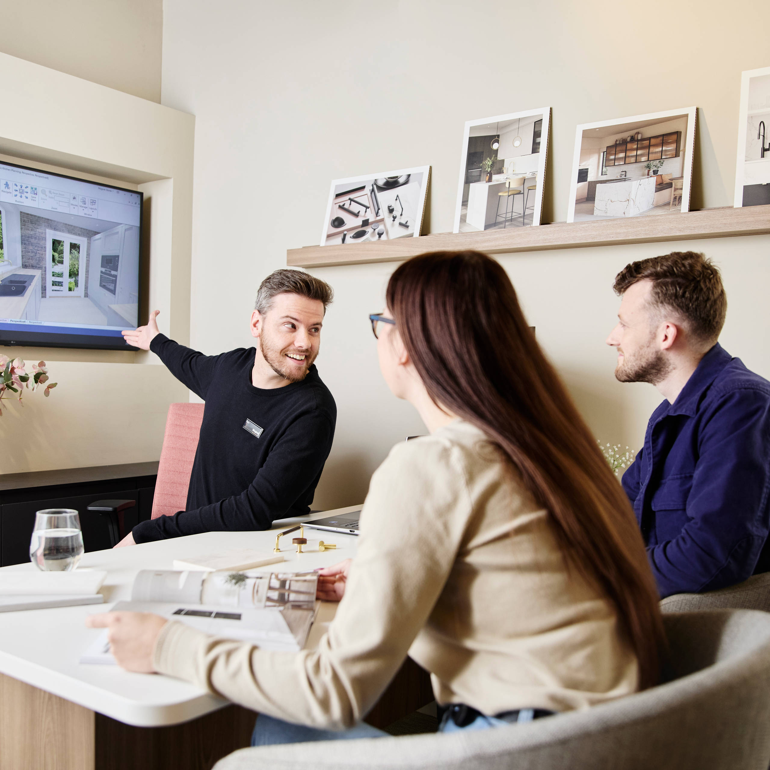 Magnet kitchen designer consulting customers in a Magnet store, showing a kitchen design.