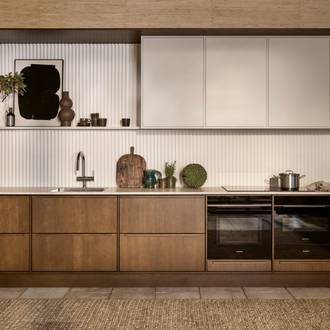 Mørk eg køkkenbænk Forever Oak fra INVITA kombineret med overskaber Athena Sand, hvide fliser, bordplade og massiv ek håndtag, ovn og dampovn fra Siemens