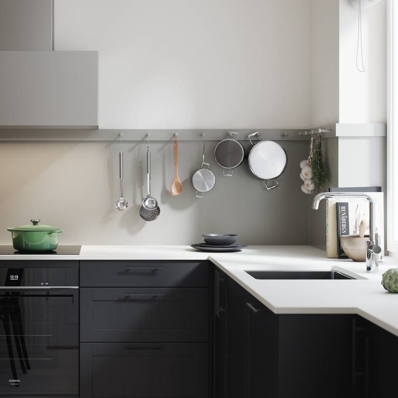 Nærbild på modern og lekker kjøkkenmodell i mdf med smal ramme og vakker eikestruktur, i sort eik med Corian Glacier white benkeplate, håndtak i sort støpejern og kran i rustfritt stål.