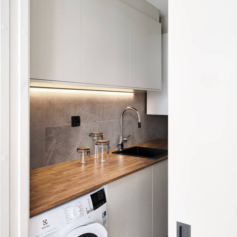 kodinhoitohuoneen ovimalleina toimii melamiini värissä Hiekka ja tasoksi valikoitui helppohoitoinen ja kestävä laminaatti sävyssä antiikkitammi.