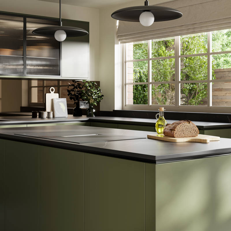View over kitchen island in Integra Soho Tailored Green cabinetry, with Dekton worktop, fluted glass vitrine wall cabinets and large windows.