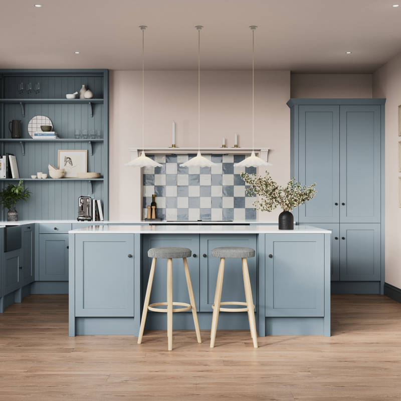 Premium Shaker kitchen Wardley Portland Blue including kitchen island with traditional detailing, black accessories, white worktop and matching blue open shelves with blue panelling and checkered tiling over range cooker.